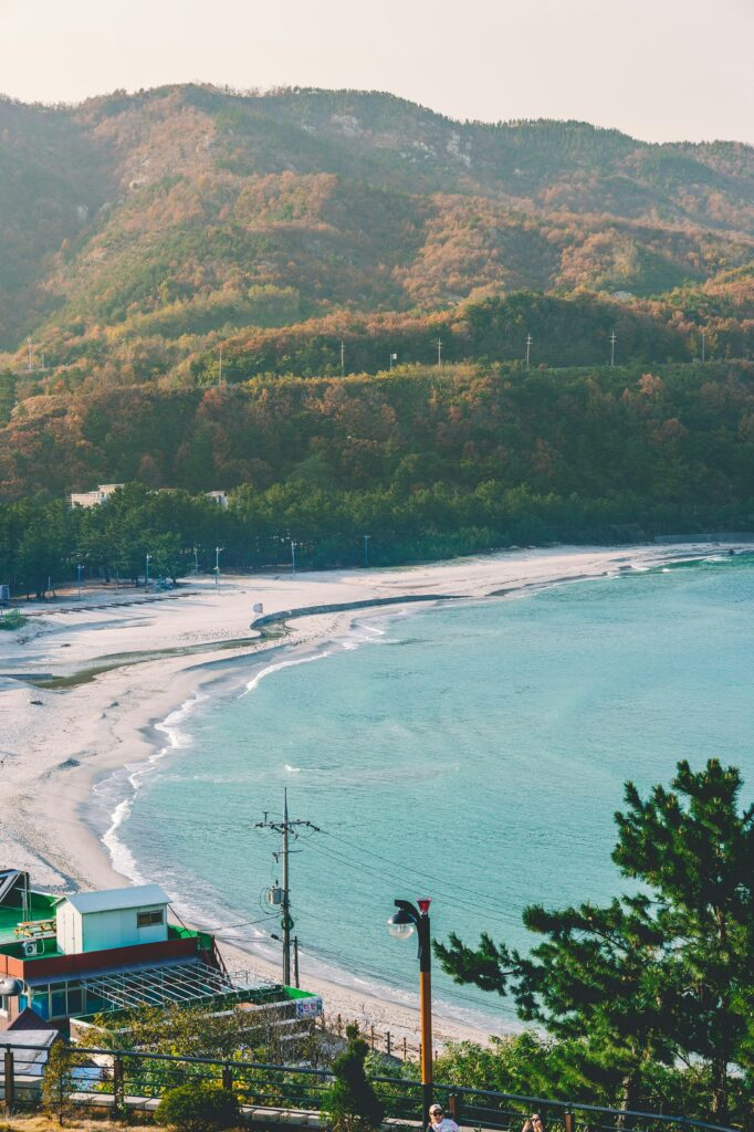 Sea line and beach from above and green hills in the background