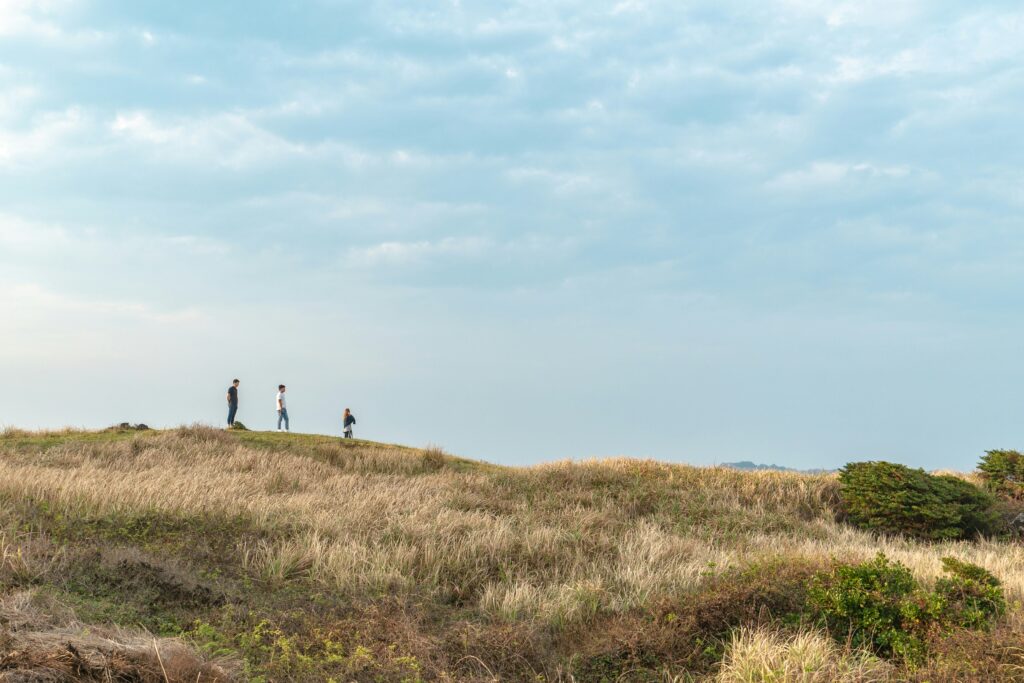 Three people walk down a hill