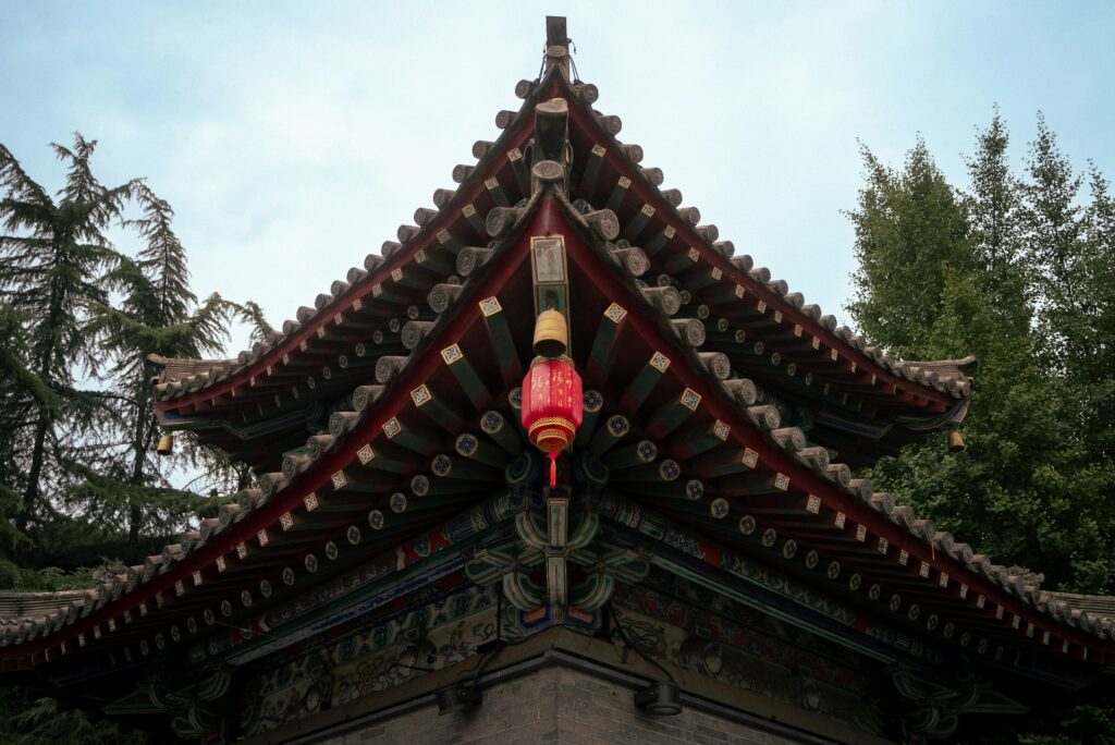 A close-up of the ornate roof of a traditional Chinese temple, featuring intricate wooden carvings, decorative tiles