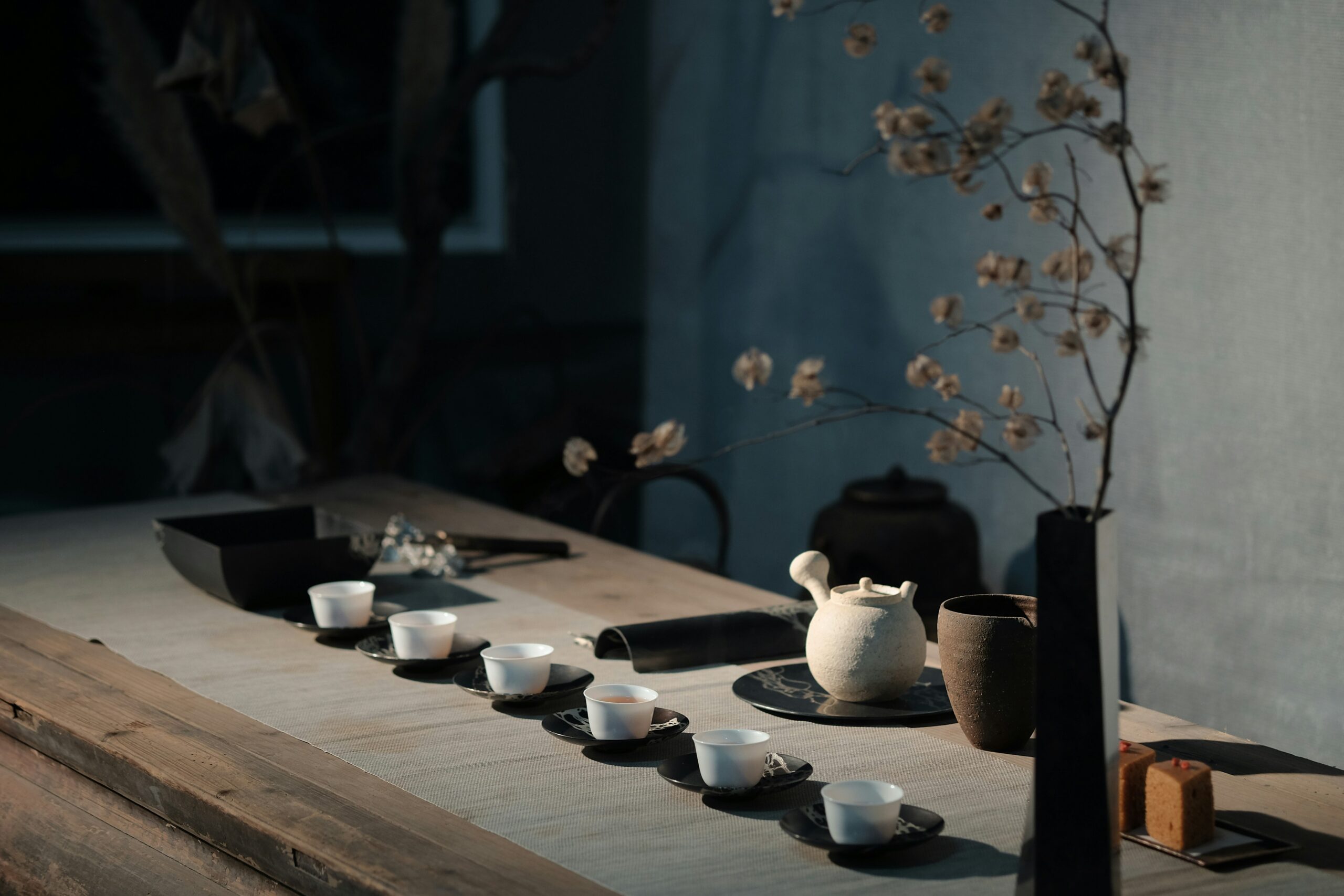 Some tea cups on a table by light from window