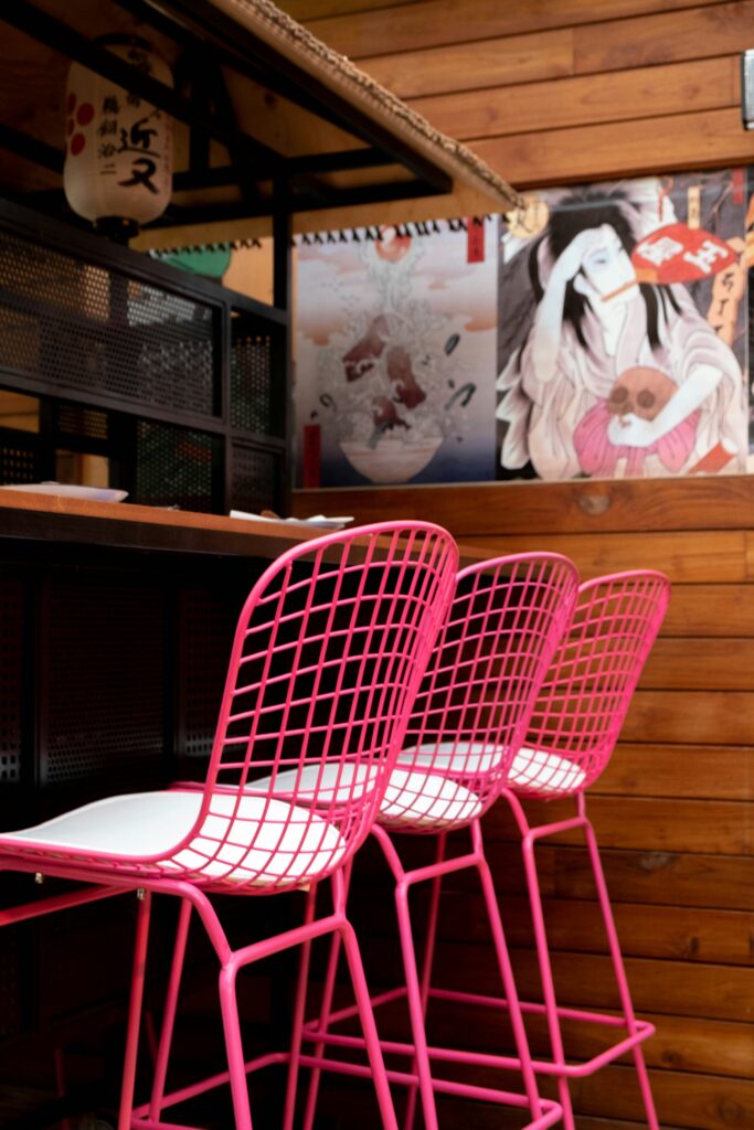 Three pink chairs in a ramen shop