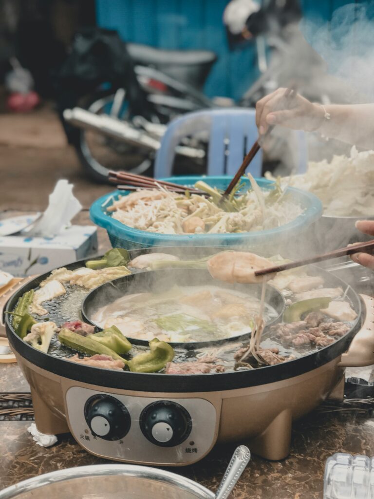 Two hot pots with two hands somewhere on the street